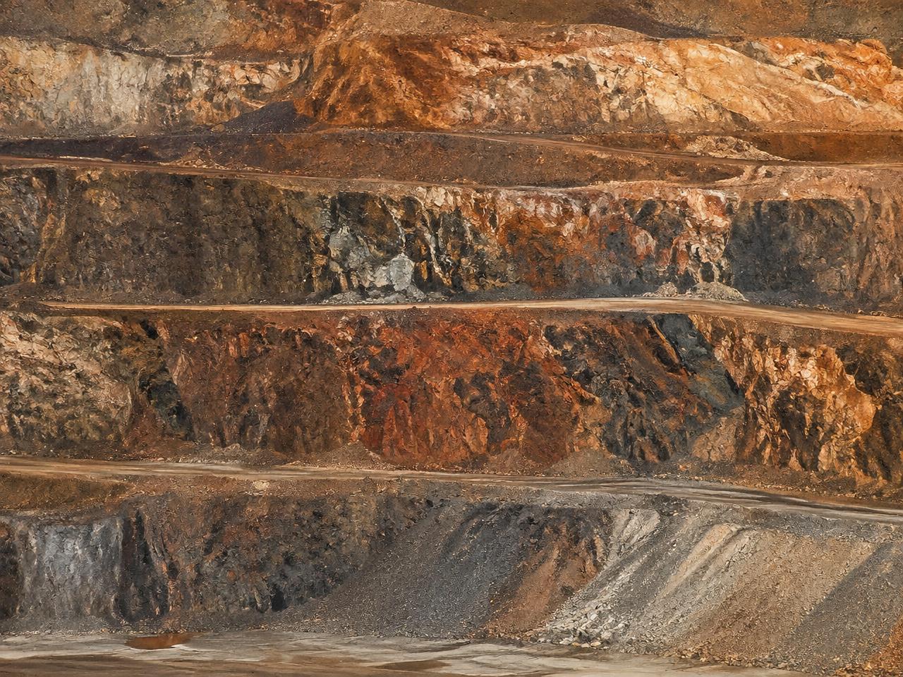 Layered mineral strata in a terraced quarry